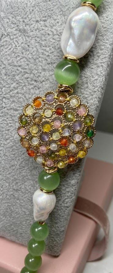 Collana lunga con occhi di gatto ed elemento multicolore.